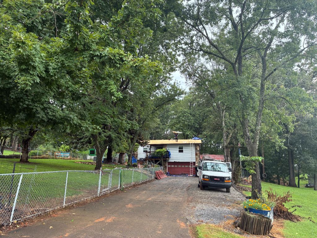 Same split-level home with roof decking exposed during metal roof removal